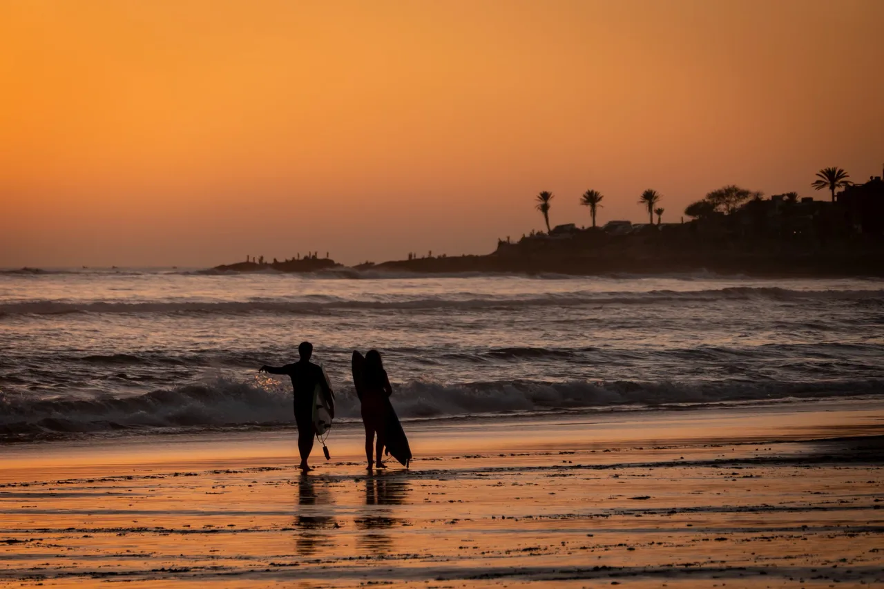 Surfers at sunset in Taghazout, Morocco